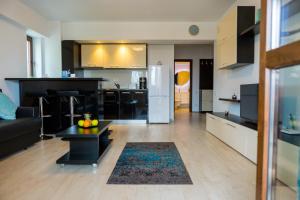 uma cozinha e sala de estar com uma cozinha em preto e branco em Alexander Apartment Mamaia em Mamaia