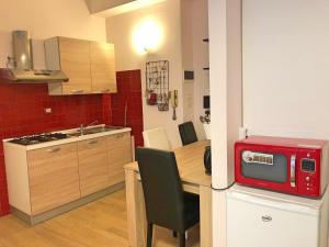 ボローニャにあるDecoriaLab Studioの小さなキッチン(テーブル、赤い電子レンジ付)