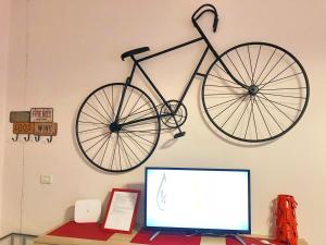 una bicicleta colgada en una pared sobre un monitor de ordenador en DecoriaLab Studio, en Bolonia