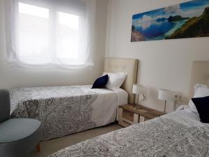 ein Schlafzimmer mit zwei Betten und einem Fenster in der Unterkunft Apartments Mirador de Villamartin LD001 in Los Dolses