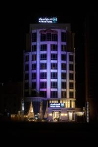 a building lit up in purple at night at Aswar Boutique Hotel in Al Khobar