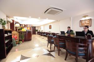 a restaurant with two people sitting at tables with laptops at Hanoi Siva Luxury Hotel & Travel in Hanoi
