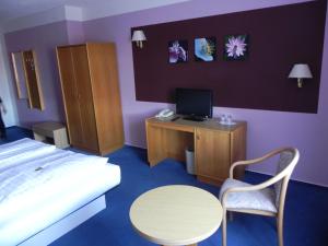 a bedroom with a bed and a table and a desk at Zur Eldenburg in Lübz