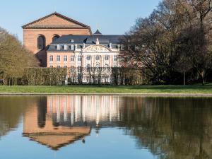 a large building with a reflection in a body of water at Hotel Haus am Berg in Trier