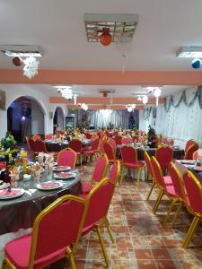 a banquet hall with tables and red chairs at Pension Bran Ioana& SPA in Bran