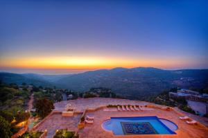 una vista aérea de un edificio con piscina y puesta de sol en Mir Amin Palace, en Beit ed-Dine