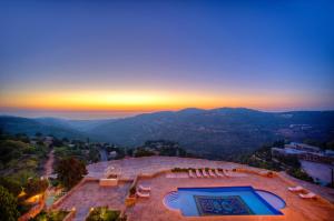 an aerial view of a building with a swimming pool and the sunset at Mir Amin Palace in Beït ed Dîne