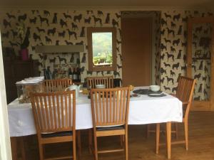 ein Esszimmer mit einem Tisch mit Stühlen und einem Spiegel in der Unterkunft Highview Bed and Breakfast in Nailsworth