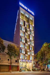 a hotel building with a lit up sign on it at Merry Hotel in Da Nang