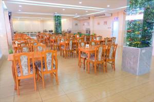 comedor con mesas y sillas de madera en Chokdee Place, en Sakon Nakhon