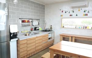 a kitchen with a sink and a refrigerator at Bae Bae Guesthouse in Jeju