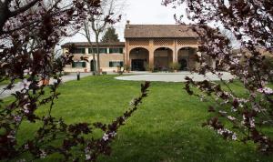 uma casa com um quintal com um edifício em Agriturismo Tenuta Casteldardo em Besenzone