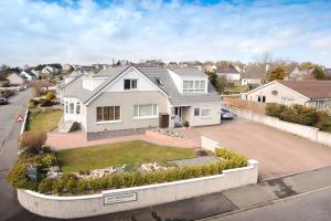 a white house on a street with a driveway at Jannel Bed & Breakfast in Stornoway