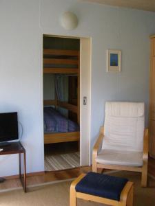 Schwarzにあるblaues Haus am Seeのベッドルーム1室(ベッド1台、椅子付)