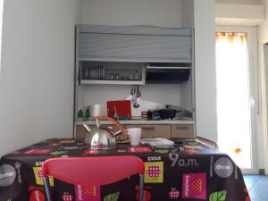 uma cozinha com uma mesa e uma chaleira para chá em Residence Désirée em Rimini