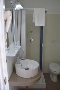 a white bathroom with a sink and a toilet at Le Stanze del Console in Gravina in Puglia