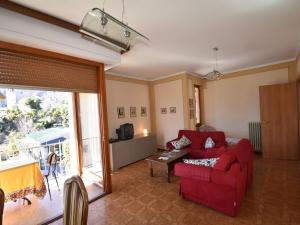 uma sala de estar com um sofá vermelho e uma televisão em Belvilla by OYO Cannero Casa Iva em Cannero Riviera