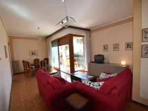 uma sala de estar com um sofá vermelho e uma mesa em Belvilla by OYO Cannero Casa Iva em Cannero Riviera