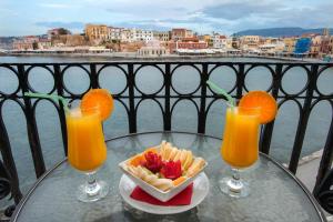 a table with two glasses of orange juice and a bowl of crackers at Casa Leone Hotel in Chania Town