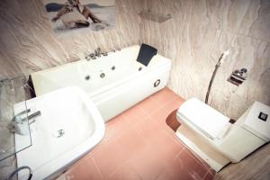 a bathroom with a sink and a tub and a toilet at Heavens Door Guest Inn in Kandy