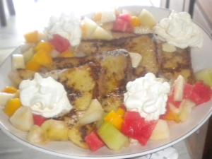 a plate of food with fruit and whipped cream at Paros Hotel Paros in Parikia