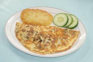 a plate of food with an omelet and bread and cucumbers at Paros Hotel Paros in Parikia