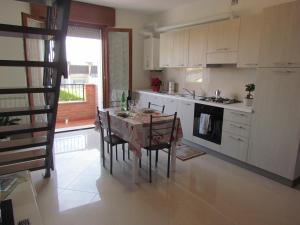 a kitchen with a table and chairs and a kitchen with a window at Siviero Apartments in Scardovari