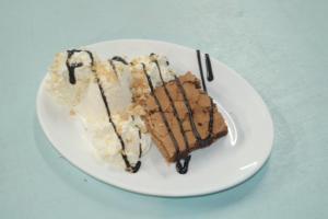 two pieces of cake on a plate on a table at Hotel Paros in Parikia