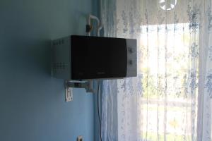 a flat screen tv hanging on a wall next to a window at Old Tiraspol Hostel in Tiraspol