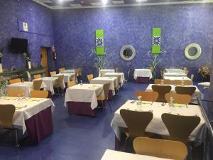 comedor con mesas, sillas y paredes púrpuras en Hostal Kavanna en San Pedro de Mérida