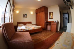 a bedroom with a bed and a desk and a chair at Aurora Guest House in Nesebar