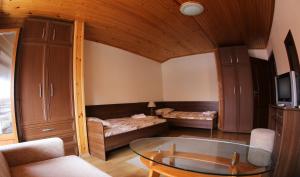 a living room with a glass table in a room at Aurora Guest House in Nesebar