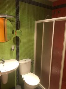 a green tiled bathroom with a toilet and a sink at Hostal Kavanna in San Pedro de Mérida +9 photos