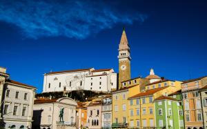 a city with a clock tower on a hill at Apartment Alex in Piran