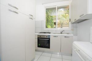a white kitchen with a sink and a window at Lignano Luxury Villa***** in Lignano Sabbiadoro +11 photos