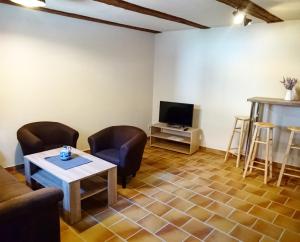 a living room with a couch and a table and a tv at Hotel garni Tilia in Quedlinburg