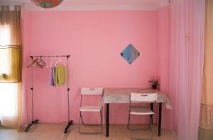 a pink room with a table and two chairs at Habitaciones cerca del mar in Reus