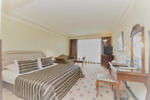 ein Hotelzimmer mit Bett und Schreibtisch in der Unterkunft Karaca Hotel in Izmir