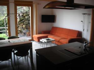 ブリッサーゴにあるFerienparadies Alla Vite in Brissagoのリビングルーム(オレンジ色のソファ、テーブル付)