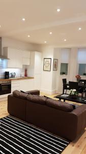a living room with a brown couch and a kitchen at Apartment at 5 Victoria Parade in Ramsgate