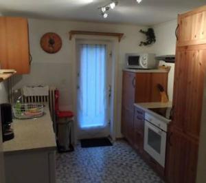 a kitchen with a sink and a door with a microwave at Altes Tagelöhnerhaus von 1510 mit Garten und Parkplatz in Goslar