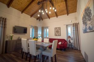 a dining room with a table and a red couch at Vorto House in Agios Leon