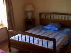 1 dormitorio con cama de madera y almohada azul en Marie France 's home, en Sacey