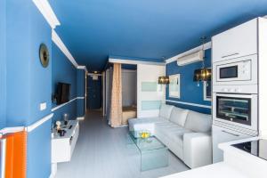un soggiorno con divano bianco e pareti blu di Luxury Torremolinos a Torremolinos