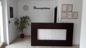 a television in a room with a clock on the wall at Family нouse -Нotel Asai in Ravda