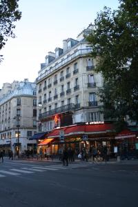 - un bâtiment dans une rue où les gens marchent devant dans l'établissement Hotel Rivoli, à Paris