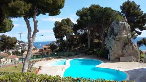 a swimming pool in a resort with a rock at Mediterrania 98 in Torroella de Montgrí