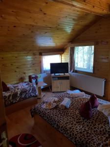 - une chambre avec 2 lits dans une cabane en rondins dans l'établissement Pension Bran Ioana, à Bran