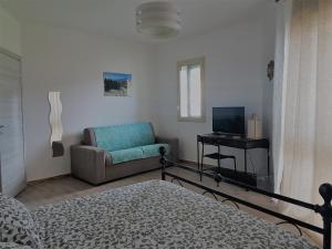 a living room with a couch and a television at La Porta dell'Alcantara in Gaggi