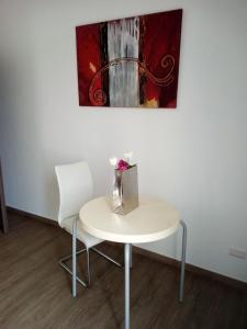 un tavolo bianco, due sedie bianche e un quadro di B&B del Capo a Santa Ninfa